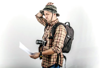 Young man looking at camera against white background