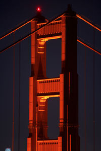 Low angle view of illuminated bridge against sky at night