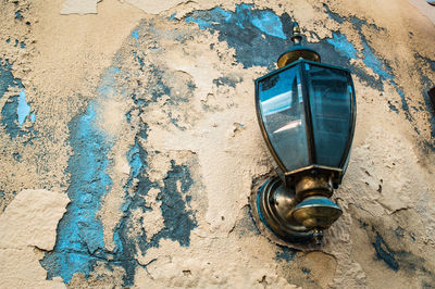 Close-up of old weathered wall with a vintage metal street lamp