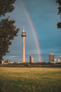 Scenic view of rainbow over field against sky