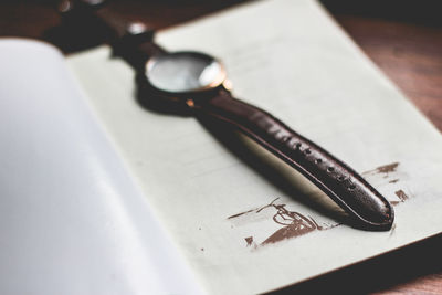 Close-up of wristwatch on book