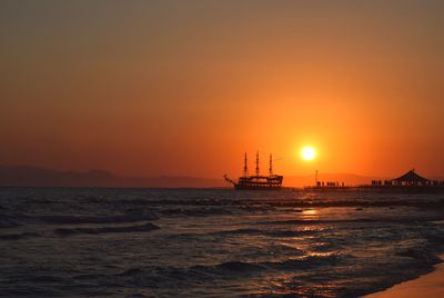 Silhouette ship in sea against sky during sunset