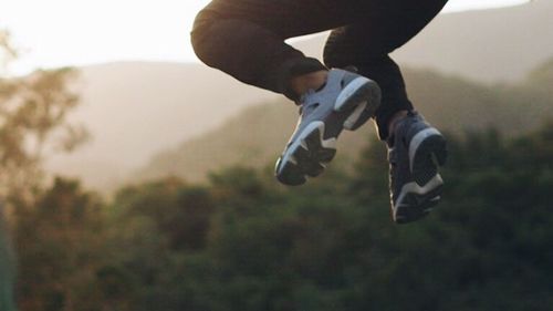 Low section of man jumping outdoors