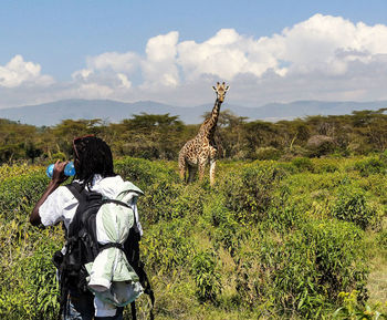 Rear view of person on field against sky