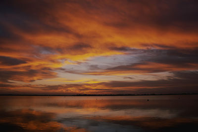 Scenic view of sea against dramatic sky during sunset