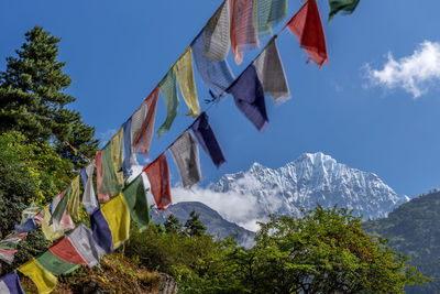 Low angle view of flags on mountain against sky