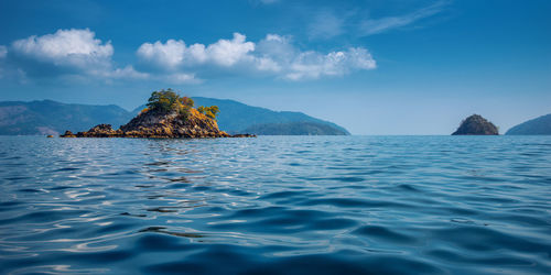 Scenic view of rocks in sea against blue sky
