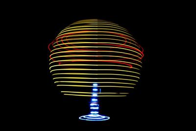 Close-up of illuminated lighting equipment against black background