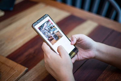 High angle view of person using mobile phone on table