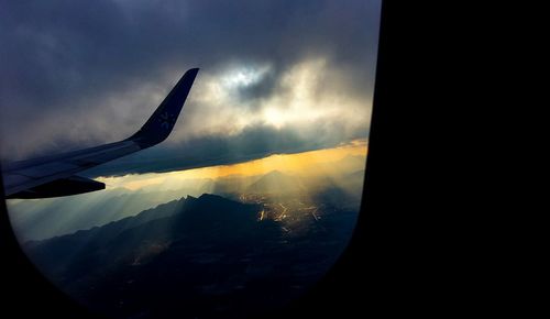 Airplane flying in sky during sunset