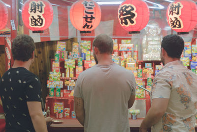 Rear view of people standing at store