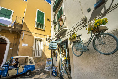 Low angle view of bicycle parked on street against buildings