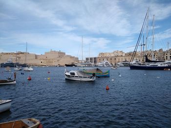 Sailboats moored in sea against sky