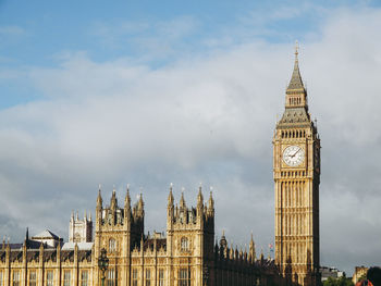 Buildings in city against cloudy sky