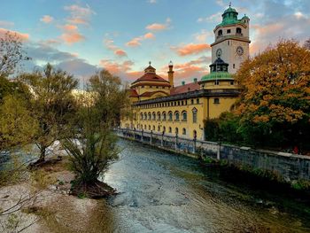 Bridge over river amidst buildings against sky