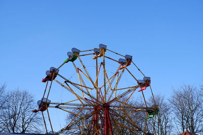 Low angle view of electricity pylon against clear blue sky