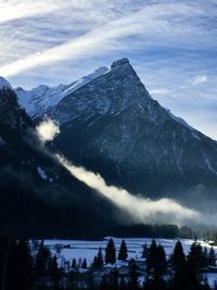 Scenic view of snowcapped mountains against blue sky