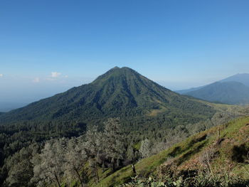 Scenic view of mountains against blue sky