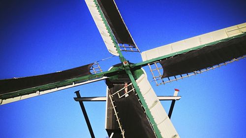 Low angle view of crane against clear blue sky