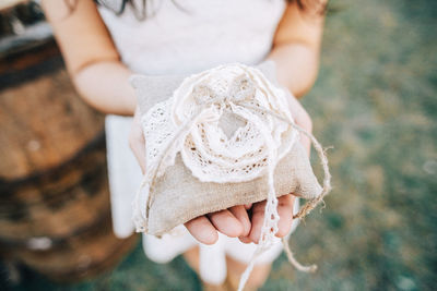 Close-up of woman holding burlap ring bag