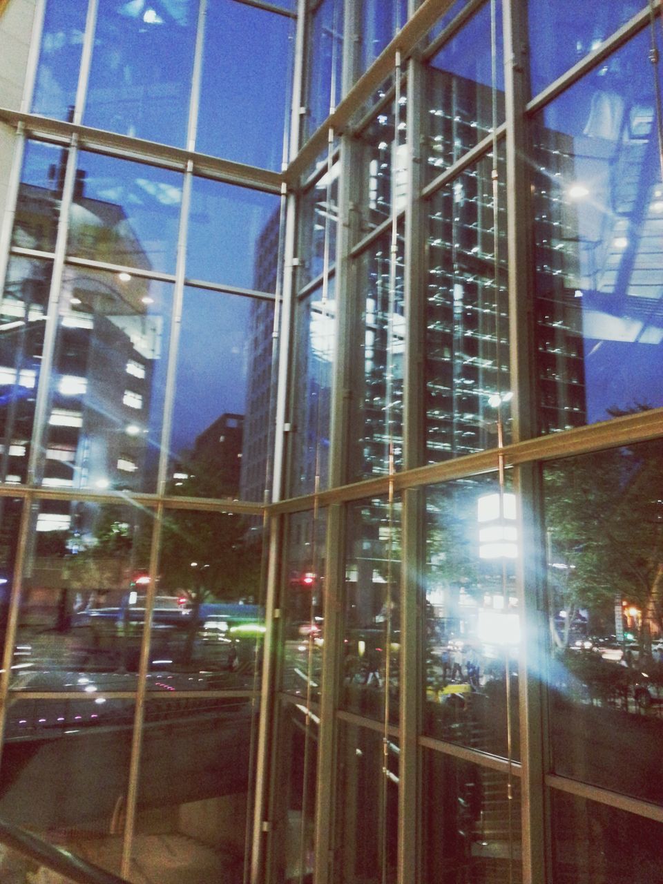 glass - material, architecture, built structure, transparent, reflection, indoors, window, building exterior, modern, city, glass, low angle view, office building, building, sky, city life, day, incidental people, illuminated, travel destinations