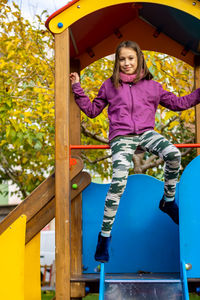 Full length of girl sitting on jungle gym