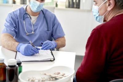 Midsection of doctor examining patient at clinic