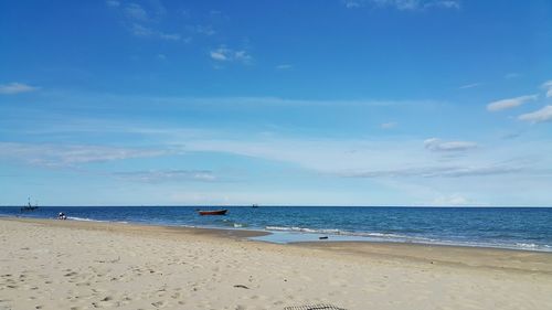 Scenic view of beach against blue sky