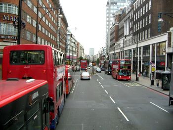 Cars on city street by buildings