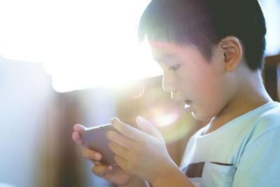 Close-up of boy using mobile phone