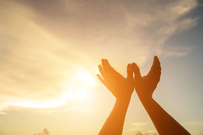 Low angle view of silhouette hand against sky during sunset