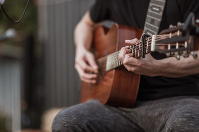 Cropped hand of guitarist playing guitar at music concert