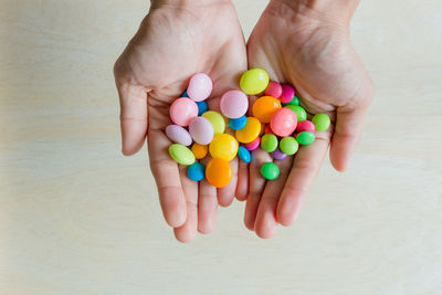 Cropped image of person holding multi colored candies