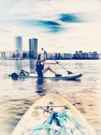 Man in sea against sky in city