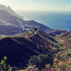 Scenic view of sea and mountains against sky