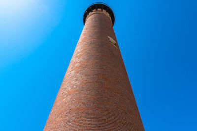 Low angle view of smoke stack against clear blue sky
