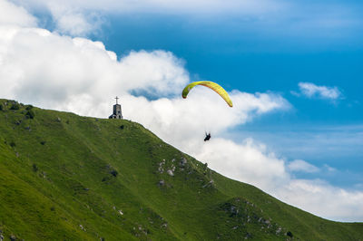 Low angle view of man paragliding against sky