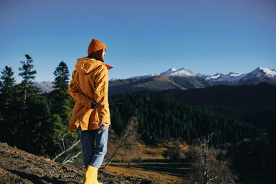 Rear view of man standing against mountain