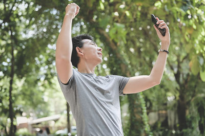 Young man in celebrate and yeah emotion when his look at mobile phone