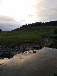 Scenic view of stream against sky during sunset