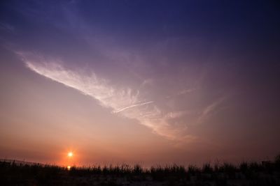 Scenic view of silhouette field against sky at sunset