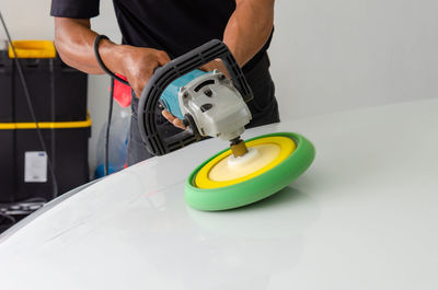 Midsection of man working with yellow umbrella