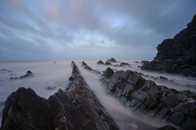 Panoramic view of sea and rocks against sky