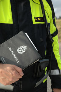 Midsection of man holding camera while standing by text