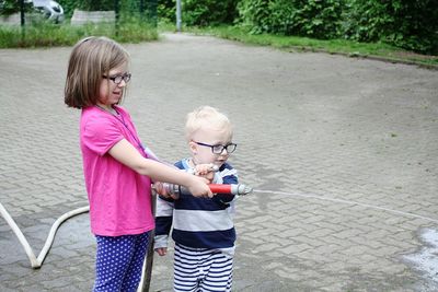 Happy siblings standing in backyard 