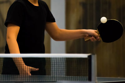 Midsection of man playing table tennis