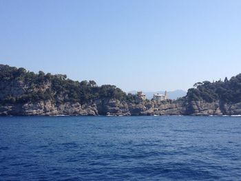 Scenic view of sea and buildings against clear sky