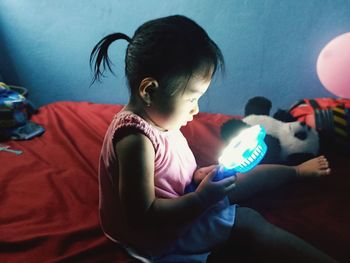 Rear view of father and girl holding camera at home