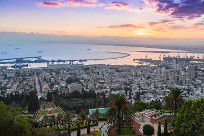 High angle view of city by sea during sunset