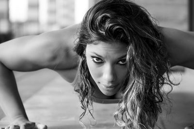 Close-up portrait of confident woman doing push-ups at home